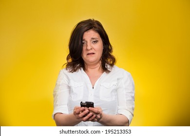 Closeup Portrait, Shocked, Business Woman, Corporate Employee Looking At Cell Phone, Seeing Bad Text Message, Email, News Isolated Yellow Background. Negative Human Emotion Facial Expression Reaction