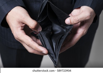 Closeup portrait of shocked man holding empty wallet, isolated on white background.