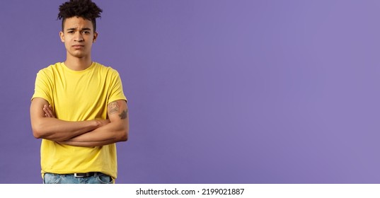 Close-up Portrait Of Skeptical, Unimpressed Young Man With Dreads, Look Judgemental And Uninterested, Cross Arms Chest, Go On Impress Me, Smirk Disappointed, Purple Background