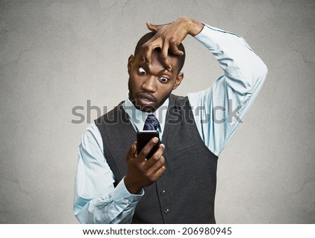 Closeup portrait sleepy, funny looking young man, fingers keeping eyes open, low energy, trying to stay awake holding smart phone isolated black background. Negative facial expression emotion, feeling