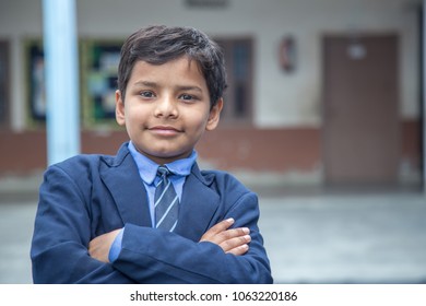 Closeup Portrait Of Smiling 6-7 Years Indian Kid, Standing Straight At School Campus In School Uniform And Looking At Camera