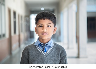 Closeup Portrait Of Smiling 6-7 Years Indian Kid, Standing Straight At School Campus In School Uniform And Looking At Camera