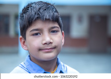 Closeup Portrait Of Smiling 8-9 Years Indian Kid, Standing Straight At School Campus In School Uniform And Looking At Camera