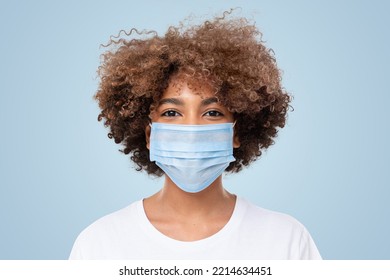 Close-up Portrait Of Smiling African American School Girl With Curly Afro Hair Wearing Medical Mask And White T-shirt, Isolated On Blue Background