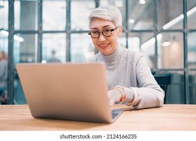 Nahaufnahme eines Porträts asiatischer Senioren im mittleren Alter Geschäftsfrau mit Laptop-Arbeit und Websurfen auf dem Schreibtisch.