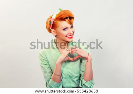 Closeup portrait smiling cheerful happy young pin up woman making heart sign with hands isolated grey wall background. Positive human emotion expression feeling life perception attitude body language
