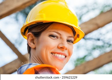 Closeup Portrait Of Smiling Female Construction Worker At Site