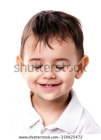 close-up portrait of a smiling little boy with closing eyes on white background