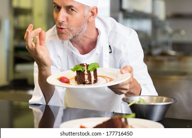 Closeup Portrait Of A Smiling Male Pastry Chef With Dessert In The Kitchen