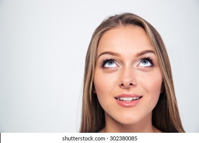 Closeup Portrait Of A Smiling Young Woman Looking Up Isolated On A White Background