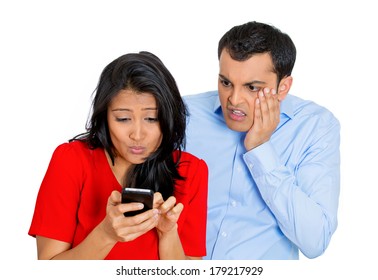 Closeup Portrait Of Sneaky Jealous Possessive Boyfriend Watching Girlfriend Happily Texting Someone Else, Isolated On White Background. Negative Emotion Facial Expression Feelings Conflict Concept