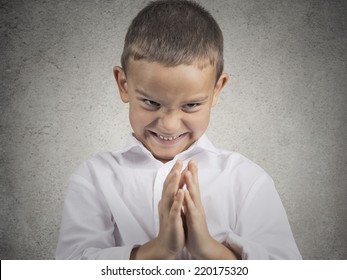 Closeup Portrait Sneaky Sly Scheming Child Boy Plotting Something Bad, Revenge Isolated Grey Background. Negative Human Emotion Facial Expression Feeling Attitude Body Language. Children Competition