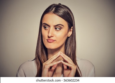Closeup portrait of sneaky, sly, scheming young woman plotting something isolated on gray background. Negative human emotions, facial expressions, feelings, attitude