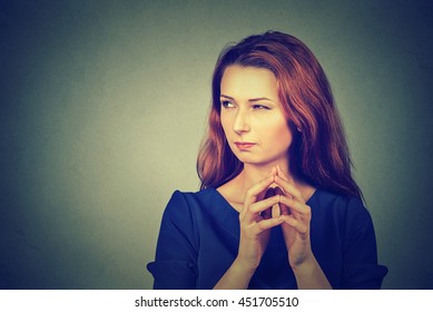 Closeup portrait of sneaky, sly, scheming young woman plotting something isolated on gray background. Negative human emotions, facial expressions, feelings, attitude