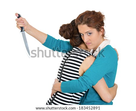 Closeup portrait, sneaky, sly young woman hugging lady, at same time trying to stab her in back, isolated white background. Negative human emotion facial expression, feelings