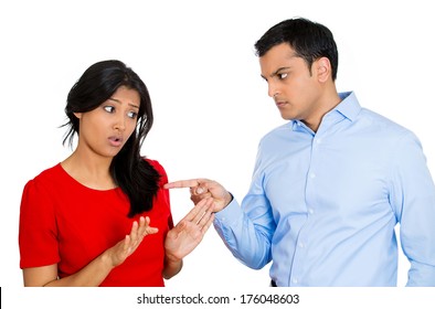 Closeup Portrait Of Stressed, Arguing Young Couple Having Serious Problems Fighting, Isolated White Background .Woman Victim Of Domestic Violence And Abuse. Husband Placing Blame And Pointing Fingers