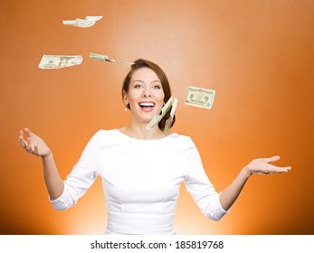 Closeup portrait super excited, laughing young woman who just won lots of money, trying to catch, throw dollar bills in air, isolated orange background. Positive emotion, facial expression, feelings.