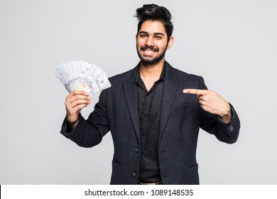 Closeup portrait of super happy excited successful young man holding money dollar bills in hand, isolated on white background.