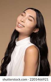 Close-up Portrait Of A Taiwanese Transgender Woman In Her 20s With Her Eyes Closed Looking Up On A Neutral Background