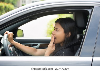 Closeup Portrait Tired Young Attractive Woman With Short Attention Span, Driving Her Car After Long Hours Trip, Yawning At Wheel, Isolated Outside Background. Sleep Deprivation