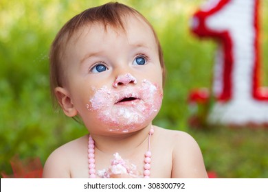 Closeup portrait of  toddler with blue eyes eating cake
