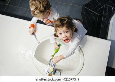 Closeup Portrait Of Twins Kids Toddler Boy Girl In Bathroom Toilet Washing Face Hands Brushing Teeth With Toothbrush Playing With Water, Lifestyle Home Style, Everyday Moments, Top View