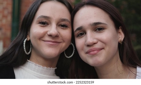 Closeup portrait of two young beautiful smiling teenage girls posing on street background. Positive models having fun and hugging - Shutterstock ID 2252323159