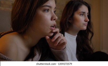 Closeup portrait of two young pretty women watching TV with excitement in a cozy apartment indoors - Shutterstock ID 1359272579