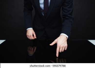 Closeup Portrait Of Unrecognizable Authority Figure Wearing Business Suit Standing Leaning On Table  Making Persuasive Hand Gesture Against Black Background