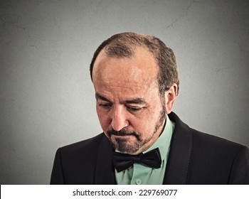 Closeup portrait very sad, depressed, desperate, alone, disappointed in life middle aged man looking down isolated on grey wall background with copy space. Negative human emotions, face expression