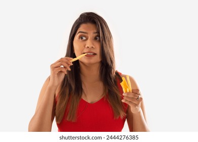 Close-up portrait of woman eating french fries against white background - Powered by Shutterstock