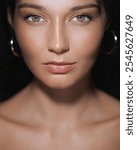 A close-up portrait of a woman with flawless skin and an intense gaze, emphasizing her natural beauty and radiant complexion. Ideal for beauty, skincare, and cosmetic product promotions.