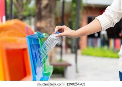 Closeup Portrait Woman Hand Throwing Empty Plastic Water Bottle In Recycling Bin.