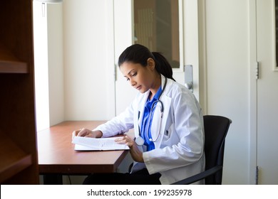 Closeup portrait, woman healthcare professional with stethoscope enjoying reading, studying in library room