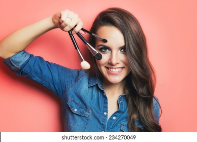 Closeup portrait of woman with makeup brushes near face