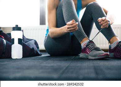 Closeup portrait of a woman tying shoelaces - Powered by Shutterstock