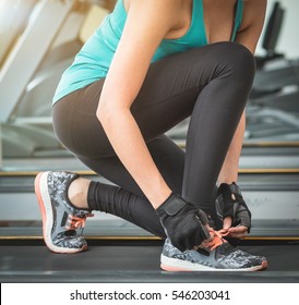Closeup portrait of a woman tying shoelaces. Beautiful woman tying shoelaces at gym .  Woman runner tying laces before training
 - Shutterstock ID 546203041