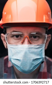 Close-up Portrait Of A Worker In A Helmet, Mask And Safety Glasses. Vertical Orientation.