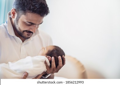 Closeup portrait of young asian Indian father holding his newborn baby with copy space. Healthcare and medical daycare nursery love lifestyle together single dad father’s day holiday concept