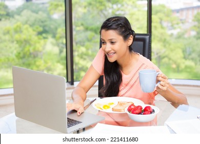 Closeup portrait, young, attractive businesswoman, kick start day with healthy breakfast, smiling on laptop. Isolated glass window indoor green trees background. The early bird catches the worm.