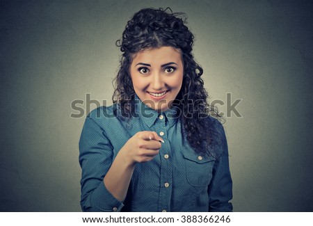 Closeup portrait of young, beautiful, excited, happy woman smiling, laughing, pointing finger towards you, camera gesture, isolated on gray wall background. Positive human emotion, attitude, reaction