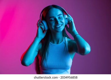 Close  up portrait young beautiful girl wearing headphones   listening music gradient pink purple background  Creative lifestyle  art importance  Concept youth culture  music  art  ad