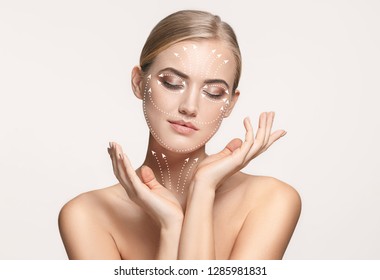 Close-up portrait of young, beautiful and healthy woman with arrows on her face. The spa, surgery, face lifting and skin care concept