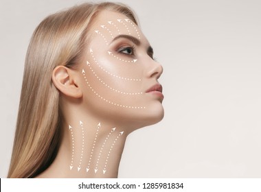 Close-up portrait of young, beautiful and healthy woman with arrows on her face. The spa, surgery, face lifting and skin care concept - Shutterstock ID 1285981834