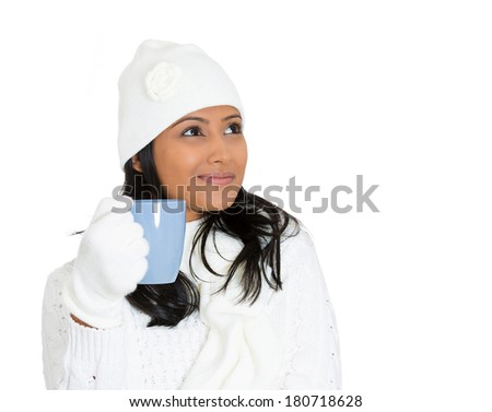 Closeup portrait of young beautiful pretty woman wearing winter gear attire sweater holding blue cup with beverage inside, isolated on white background. Positive emotion facial expression feelings.