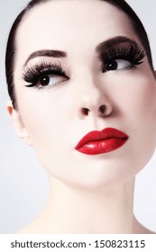 Close-up portrait of young beautiful woman with red lips and cat eyes make-up