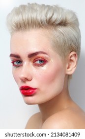 Close-up portrait of young beautiful woman with fancy glitter makeup, red lipstick and mascara