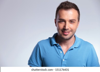 closeup portrait of young casual man looking at the camera with a smile on his face. on gray background