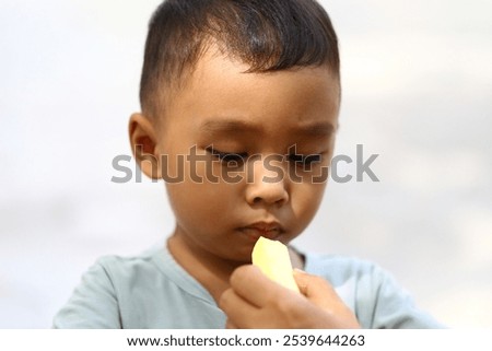 Similar – Image, Stock Photo Young child savoring a blue lollipop enthusiastically