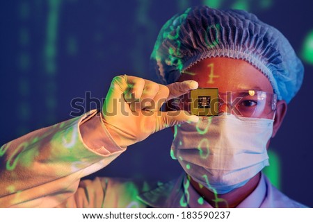 Close-up portrait of a young computer engineer with microchip instead of his eye 